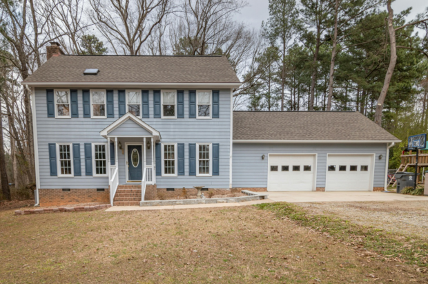 light blue house with 2 white garage doors