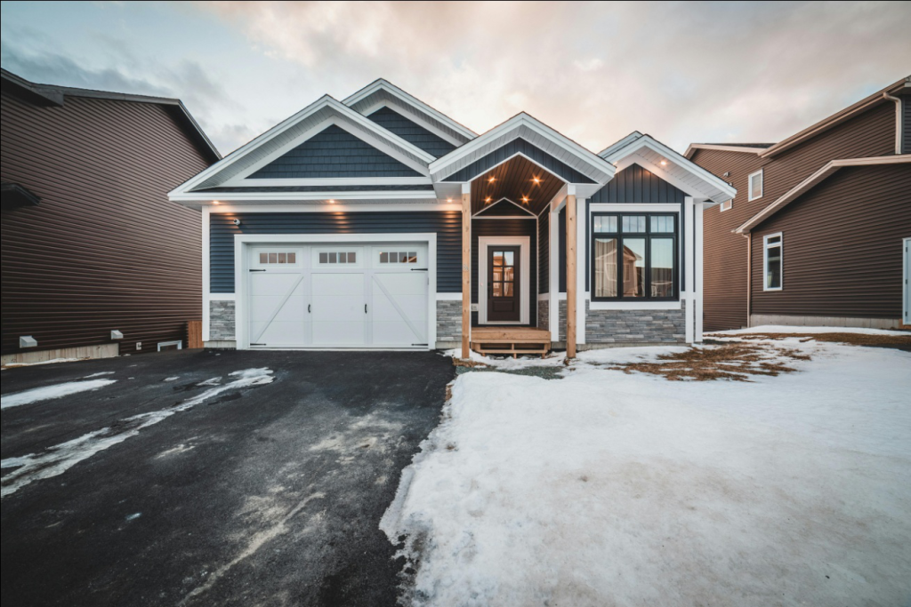 a house with a white garage door during the snow